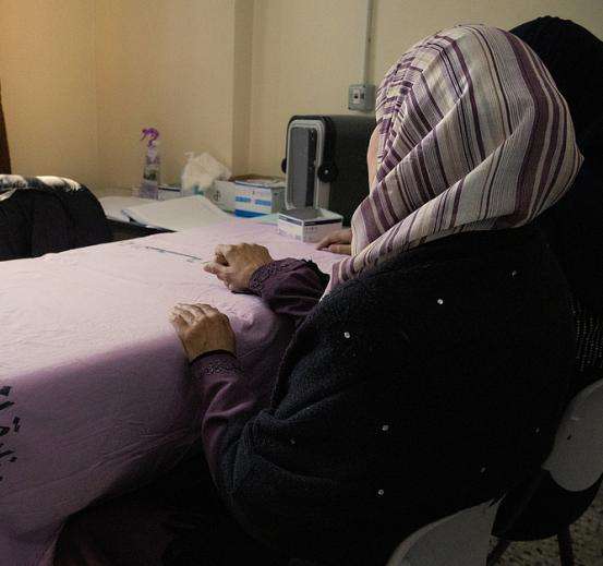 The back of a staff member sitting at a table in Gaza.